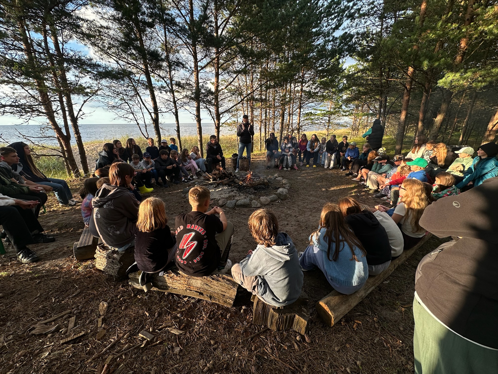 Lapsed lõkke ümber männimetsas mere ääres Happy Classesi laagris